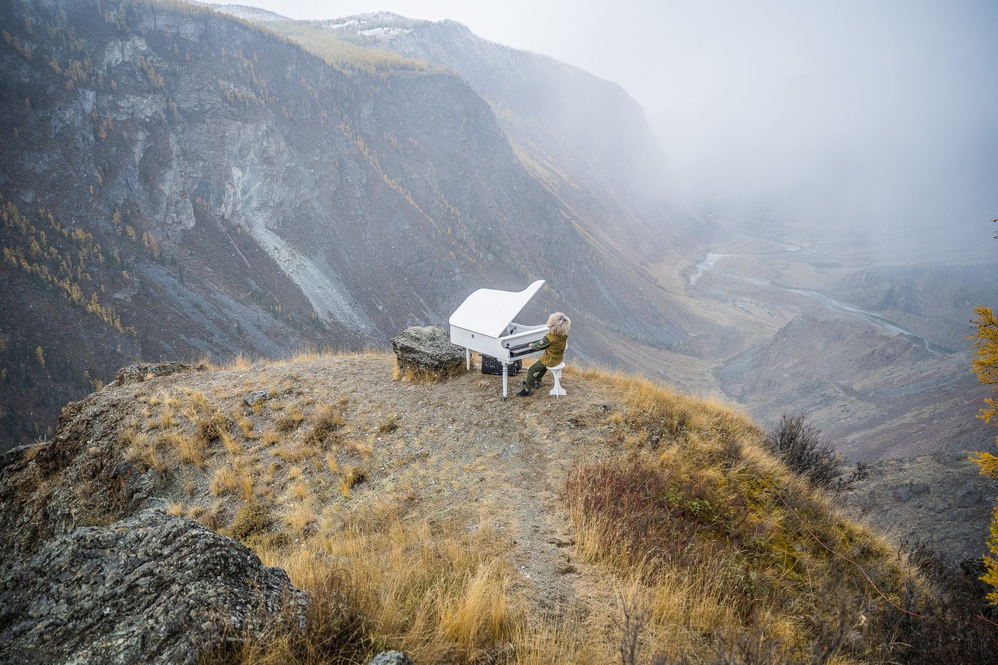 Grand piano on a cliff edge in the fog during MadWay Rally in Altai