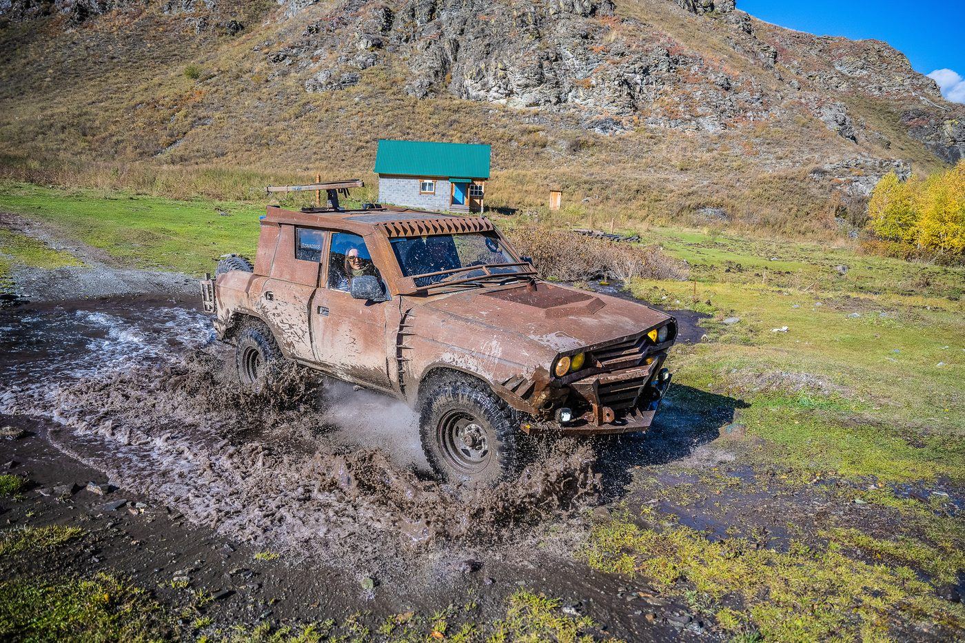 Rusty custom MadWay Rally car in the autumn forest of Altai