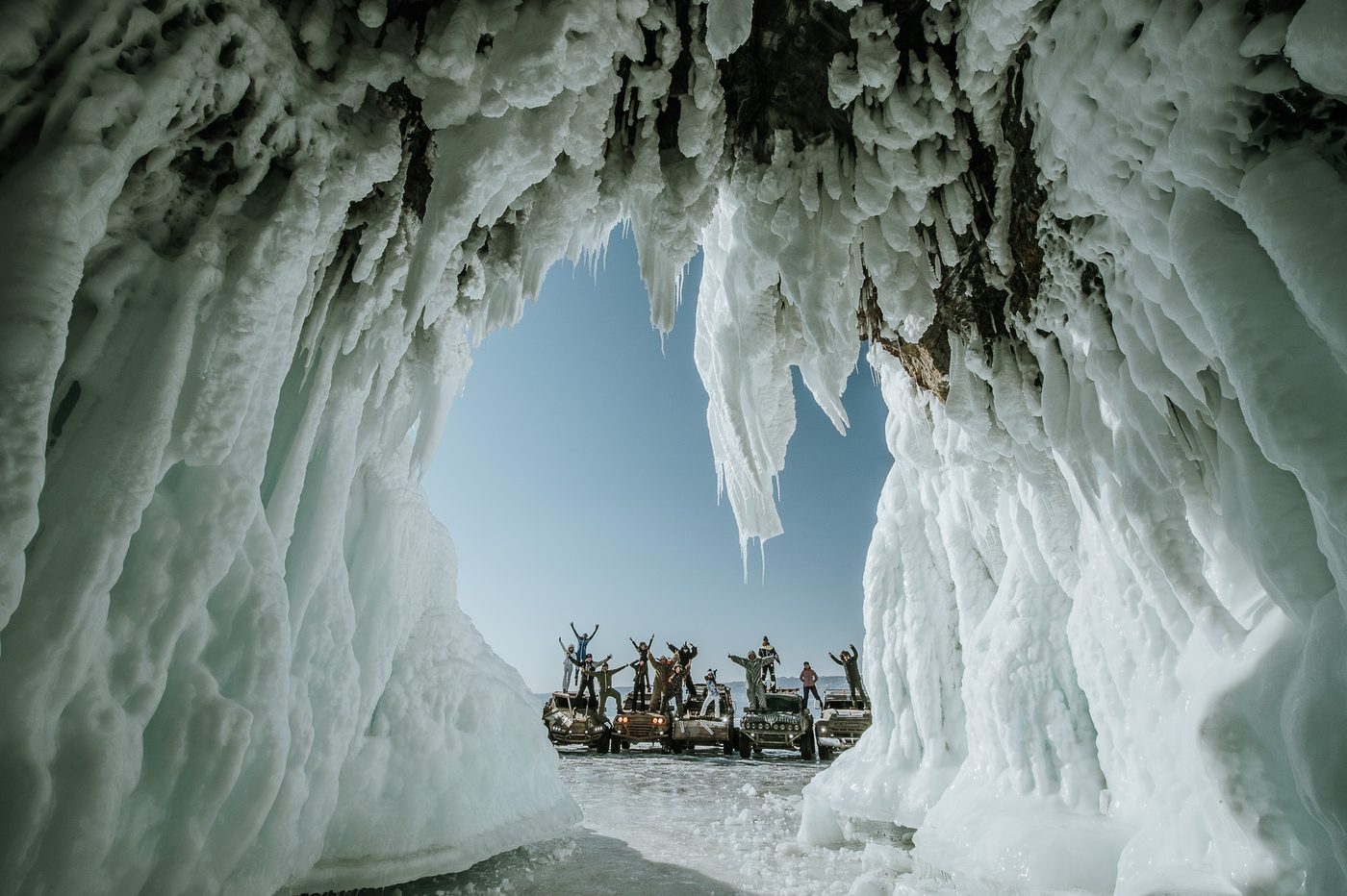 MadWay Rally participants exploring a blue ice cave on Lake Baikal