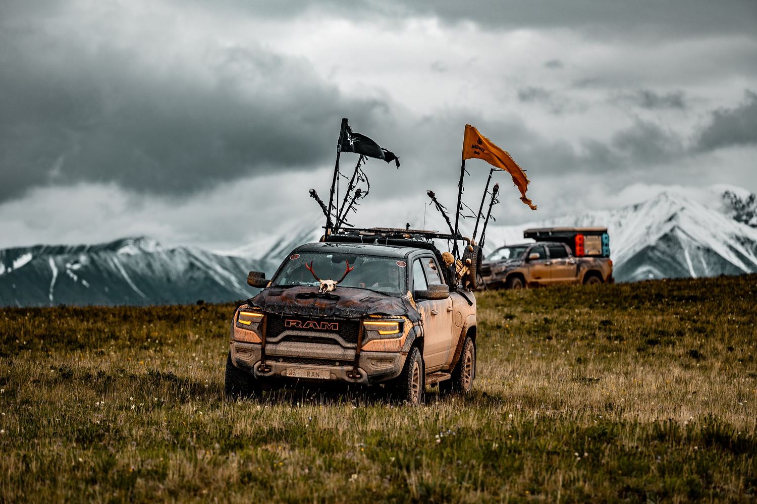 MadWay Rally cars with flags high in the Tien Shan, snow-capped peaks behind, Kyrgyzstan