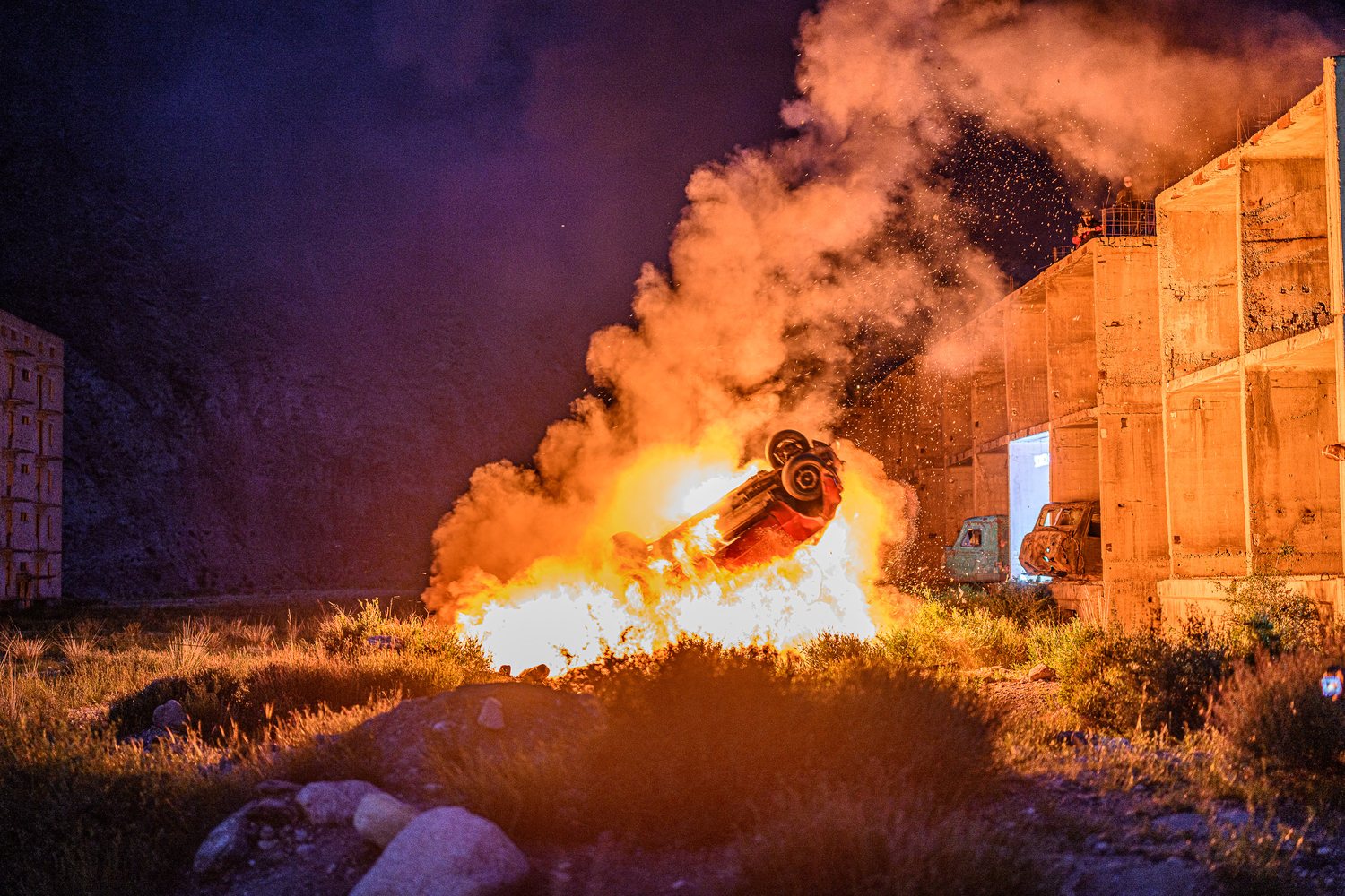Overturned car burning at night during the first MadWay Rally in Mongolia