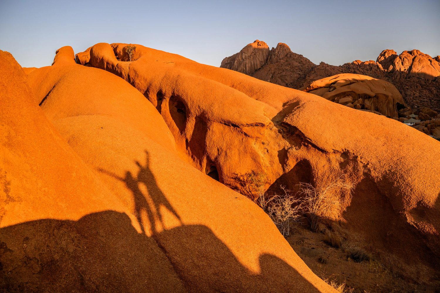 Shadows of MadWay Rally participants on the orange dunes of Namibia