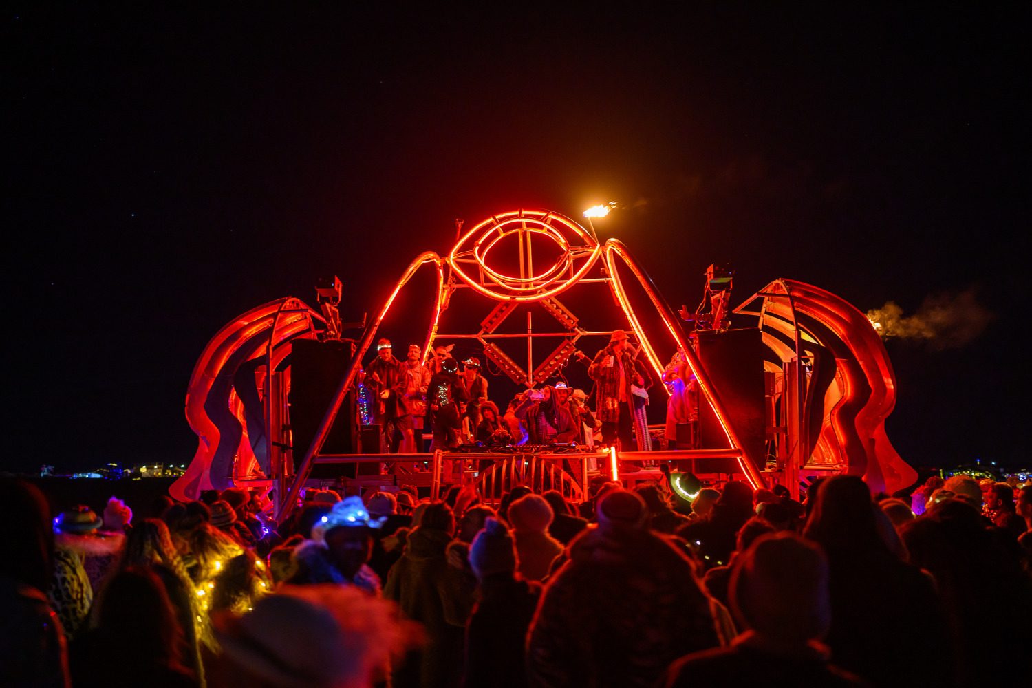 Neon-lit red skeletal sculpture and crowd at night at AfrikaBurn during MadWay Rally South Africa