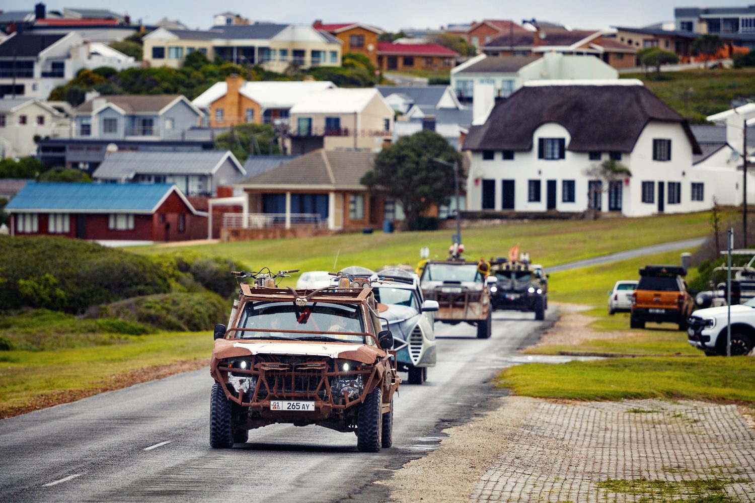 MadWay Rally convoy driving through a coastal village near Gansbaai, South Africa